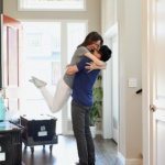 woman in gray long sleeve shirt and gray pants standing beside white wooden door