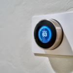 gray Nest thermostat displaying at 63