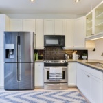 silver french door refrigerator beside white wooden kitchen cabinet